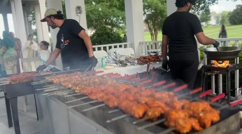 Signature Barbecue crew grilling at an outdoor celebration